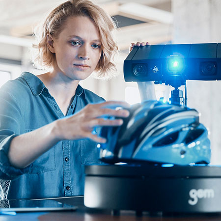 A metrologist 3D scanning a helmet