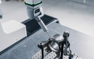 Metal part being probed on a bridge CMM